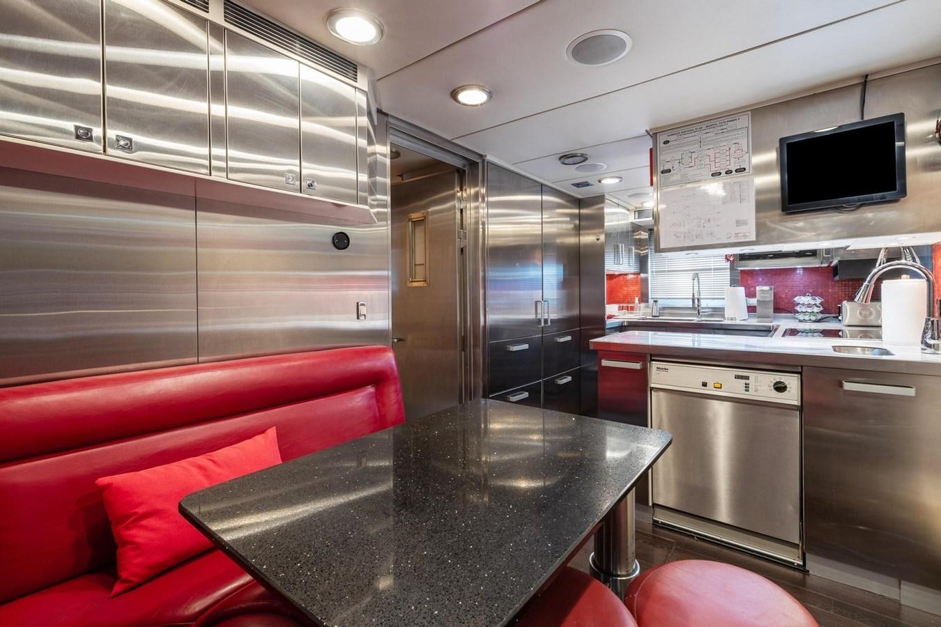 a kitchen with a bar and a tv on the wall aboard IZUMI Yacht for Sale
