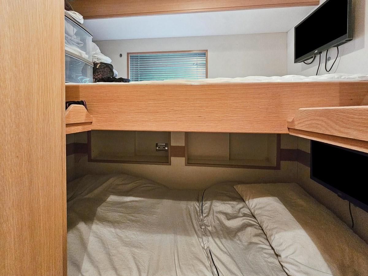 a bed with a wood headboard aboard IZUMI Yacht for Sale