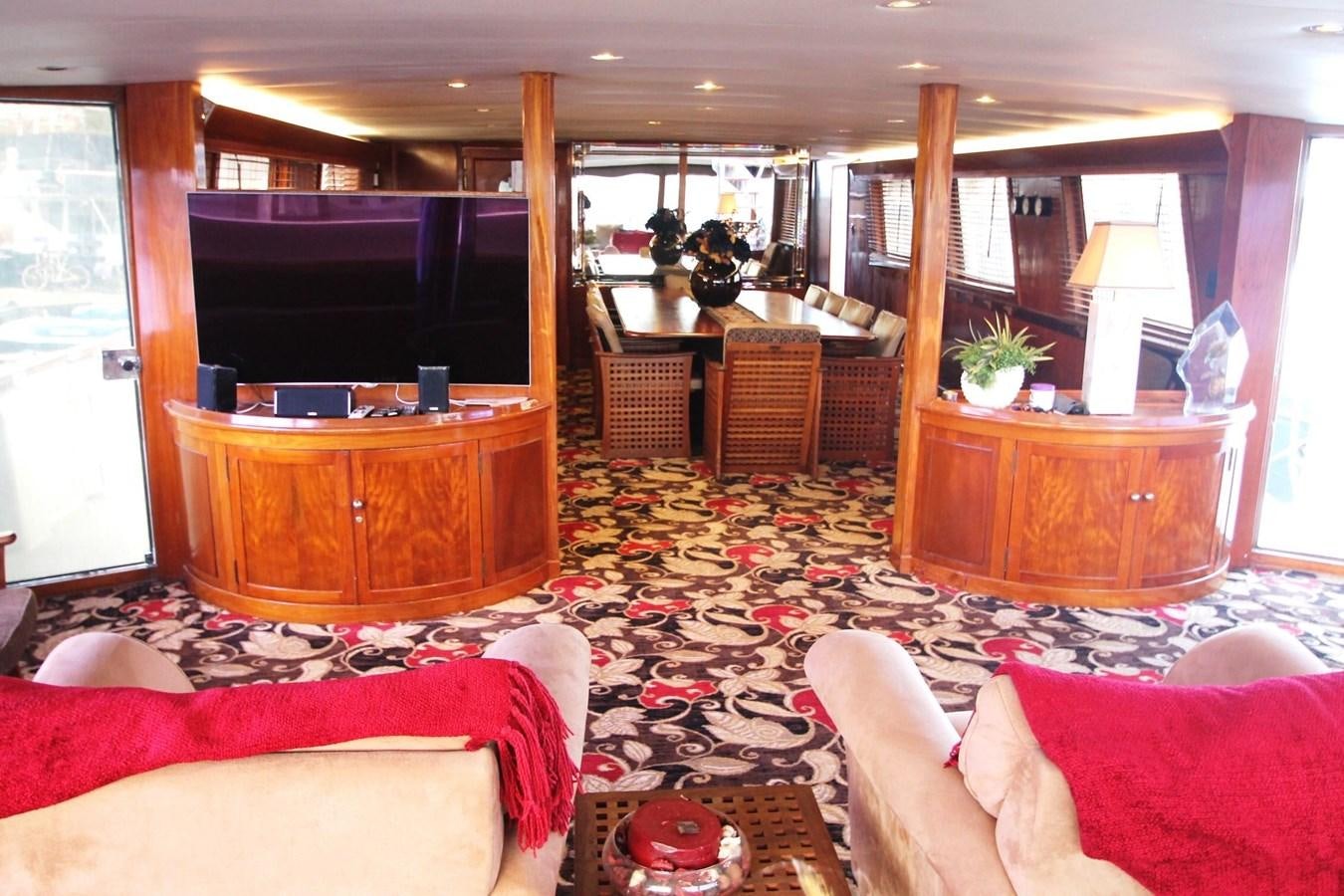 a living room with a tv and furniture aboard ENCHANTRESS Yacht for Sale