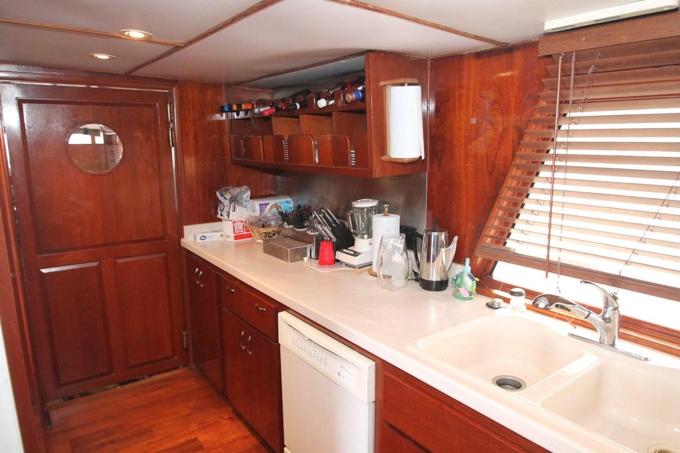 a kitchen with wooden cabinets aboard ENCHANTRESS Yacht for Sale