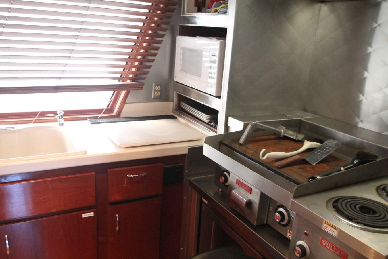 a kitchen with a stove and microwave aboard ENCHANTRESS Yacht for Sale
