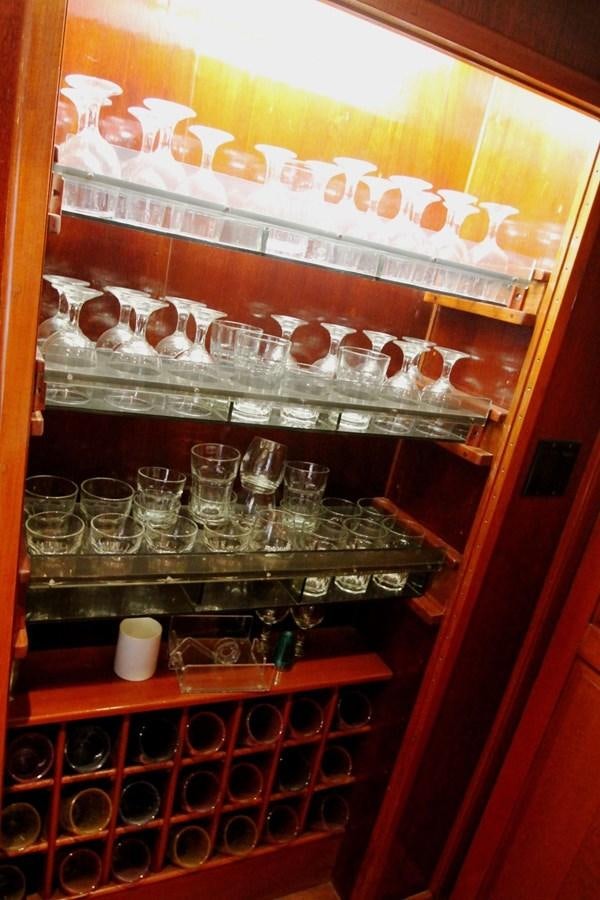 a shelf with glasses and bottles aboard ENCHANTRESS Yacht for Sale