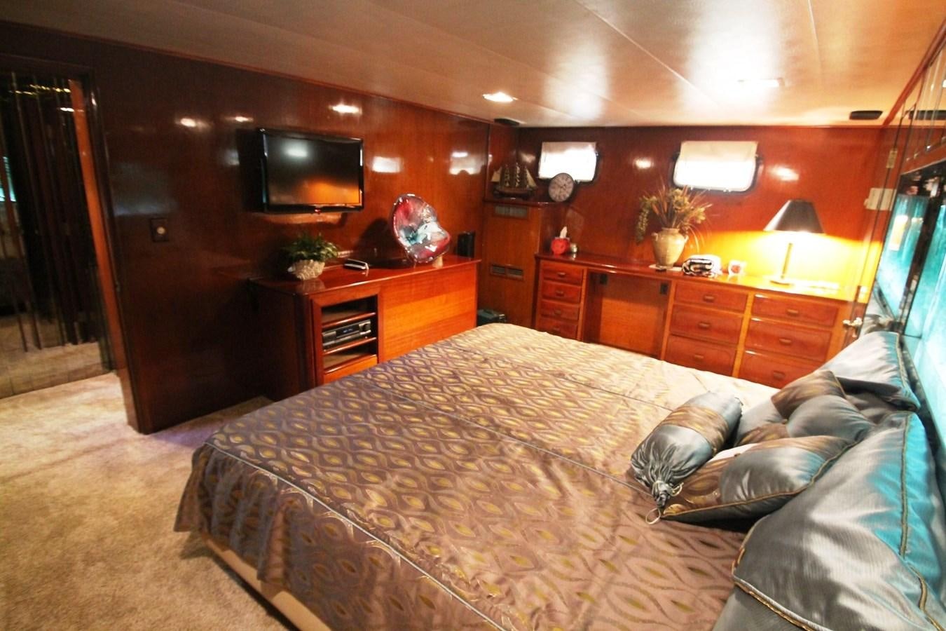 a bedroom with a bed and a television aboard ENCHANTRESS Yacht for Sale
