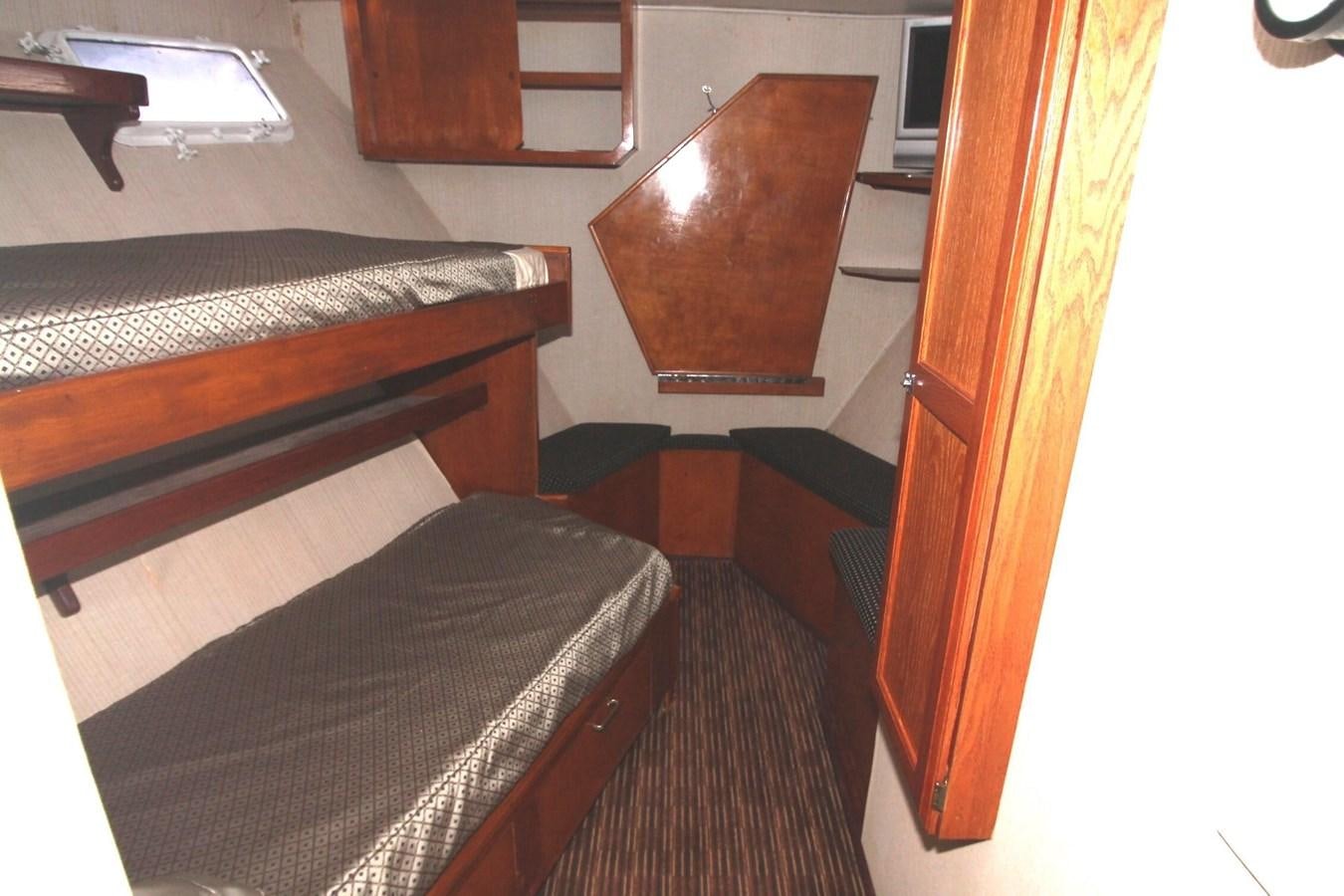a room with a bed and a desk aboard ENCHANTRESS Yacht for Sale