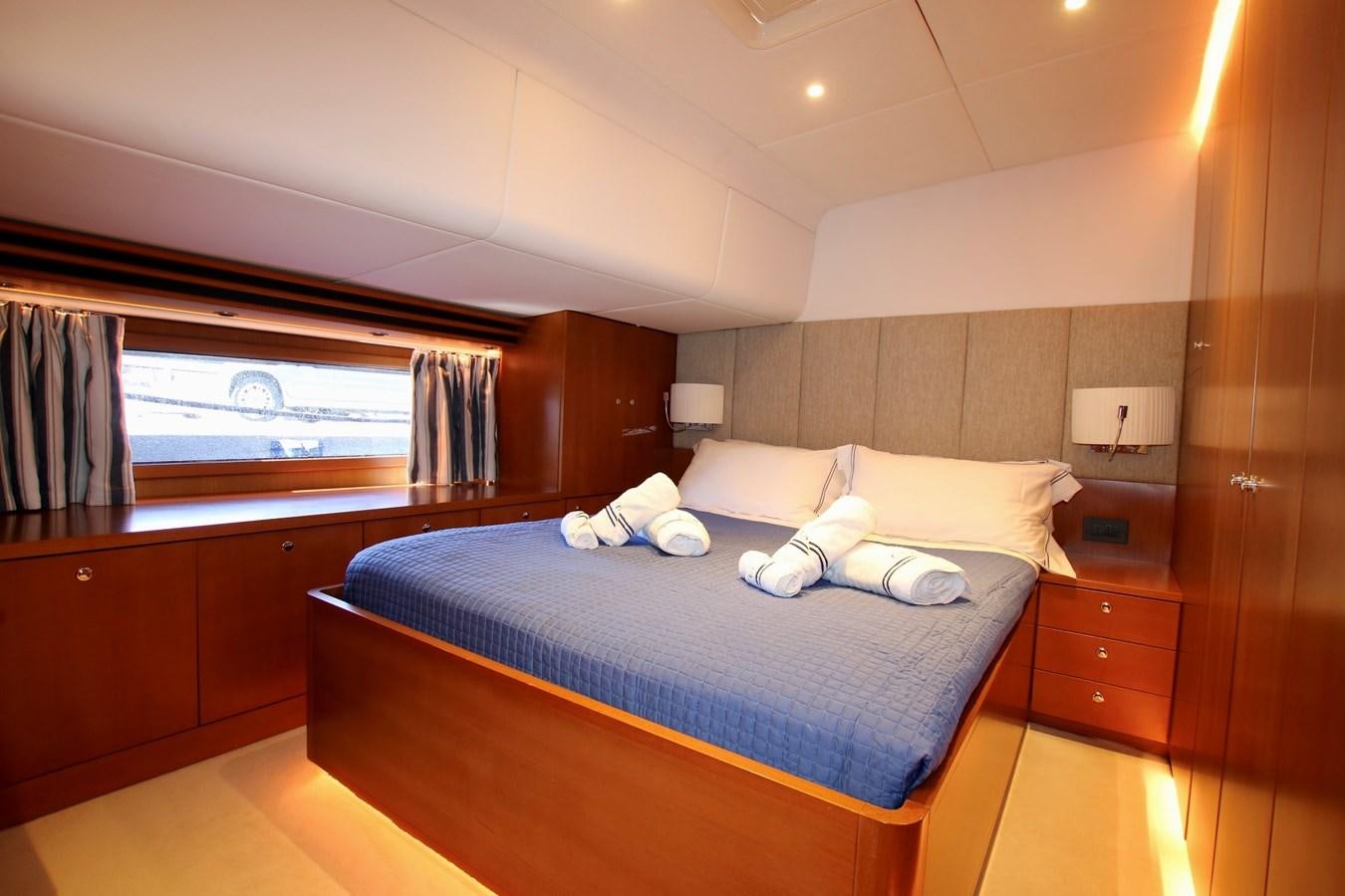 a bedroom with a bed and a window aboard CYRANO DE BERGERAC Yacht for Sale