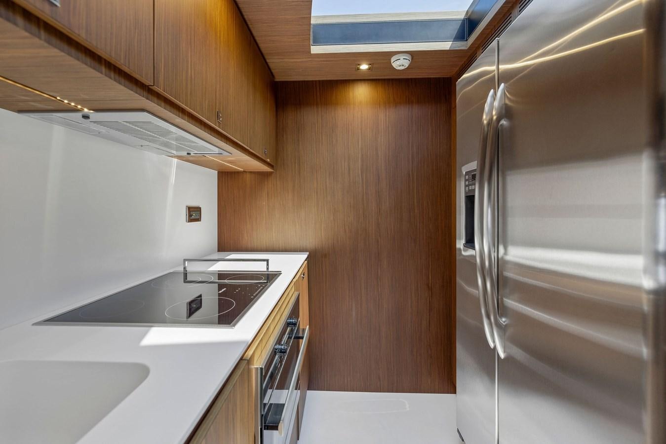 a kitchen with a refrigerator and a microwave aboard INDISCRETION Yacht for Sale
