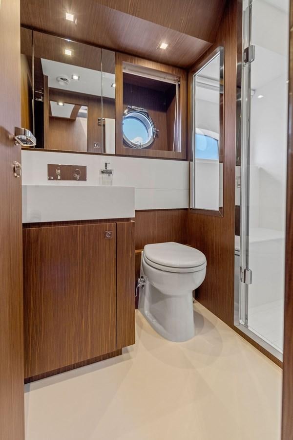 a bathroom with a toilet and a mirror aboard INDISCRETION Yacht for Sale