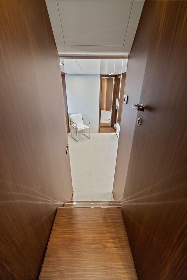 a hallway with a chair and a door aboard INDISCRETION Yacht for Sale
