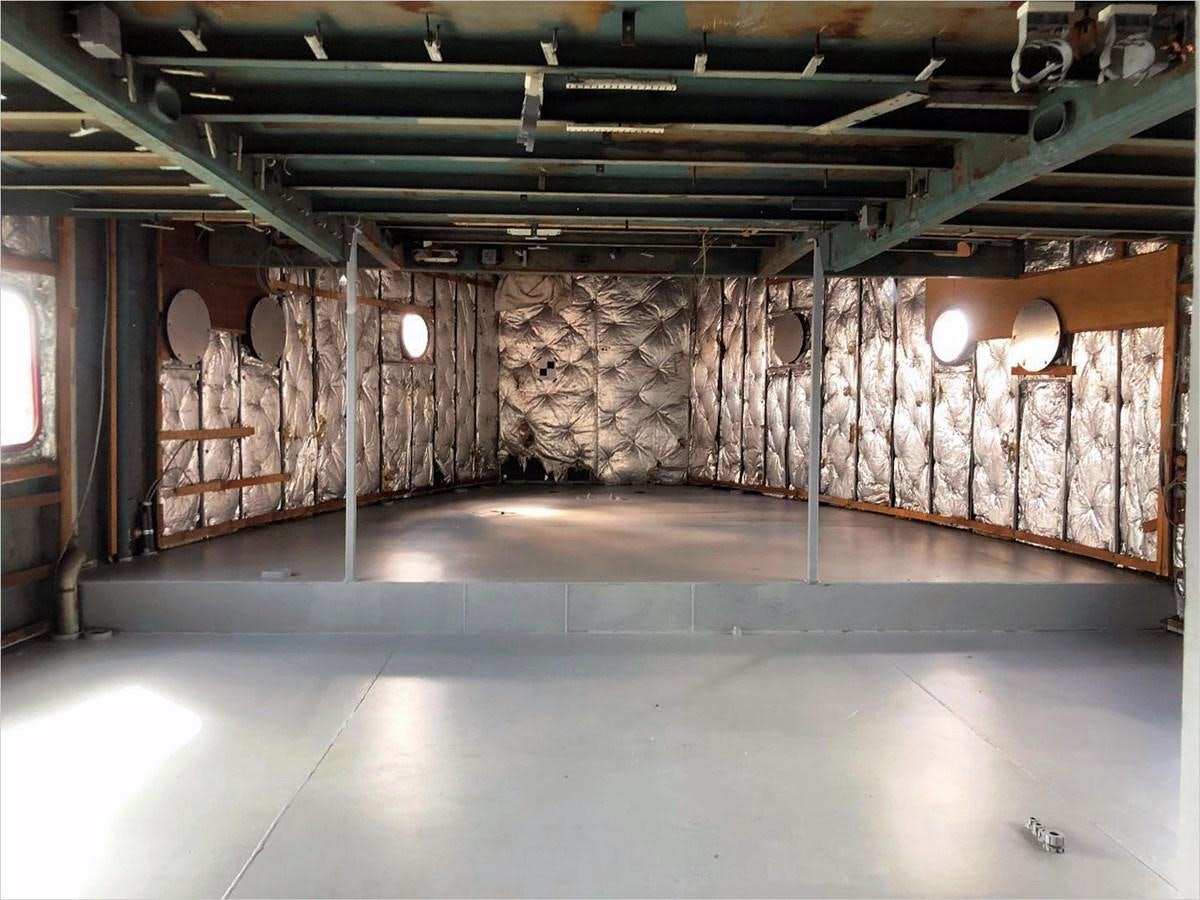 a room with a large brick wall and a large wooden floor aboard SEA MONSTER Yacht for Sale