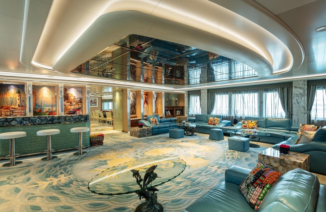 a large living room with a large blue rug and a large window aboard MOONLIGHT II Yacht for Sale