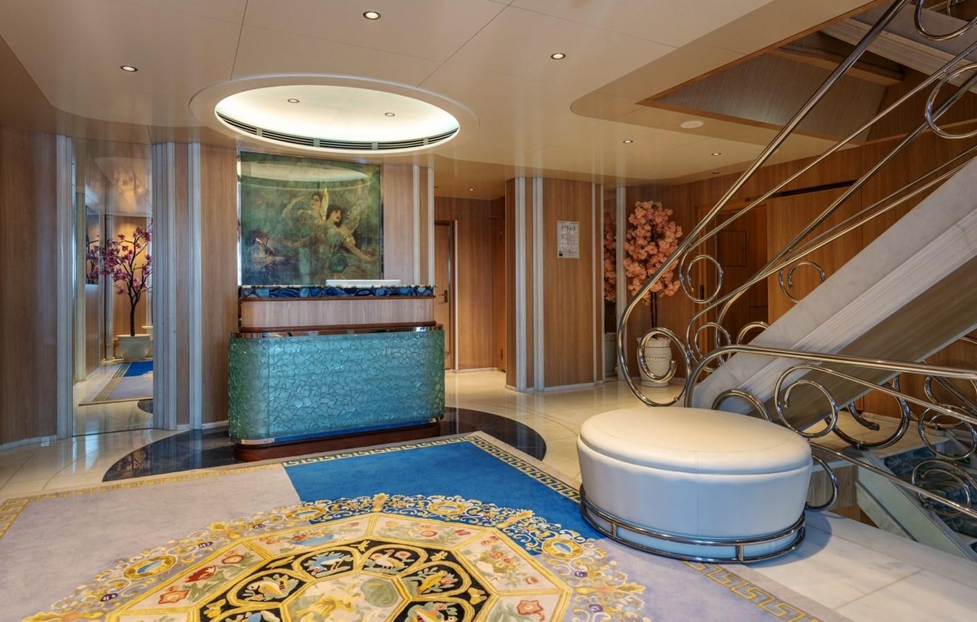 a large room with a blue couch and a chandelier aboard MOONLIGHT II Yacht for Sale