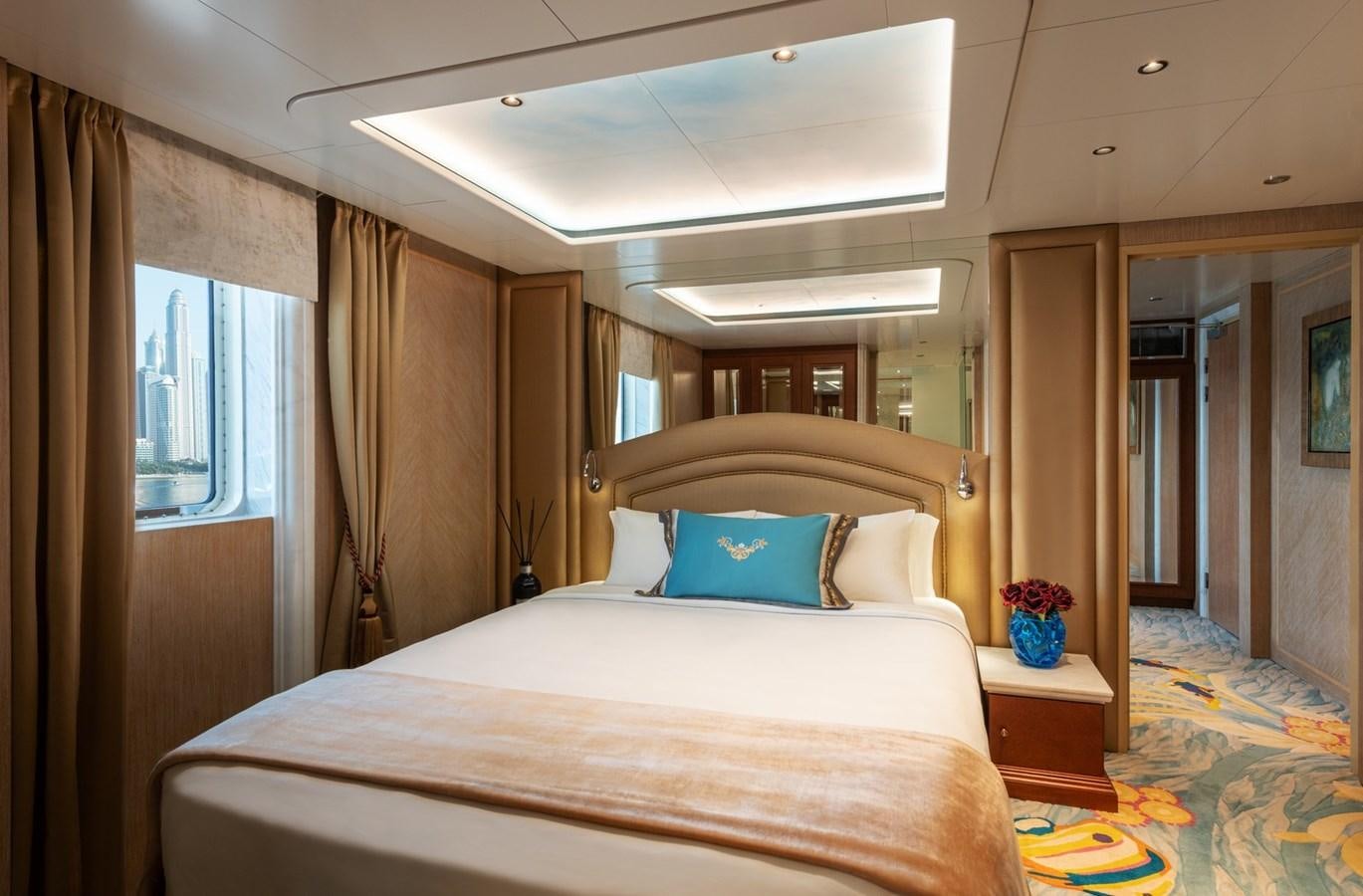 a bed with a white sheet and pillows in a room with a window aboard MOONLIGHT II Yacht for Sale