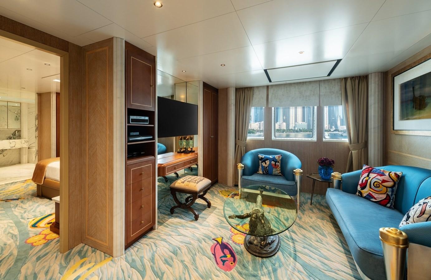 a living room with a blue couch and a table aboard MOONLIGHT II Yacht for Sale