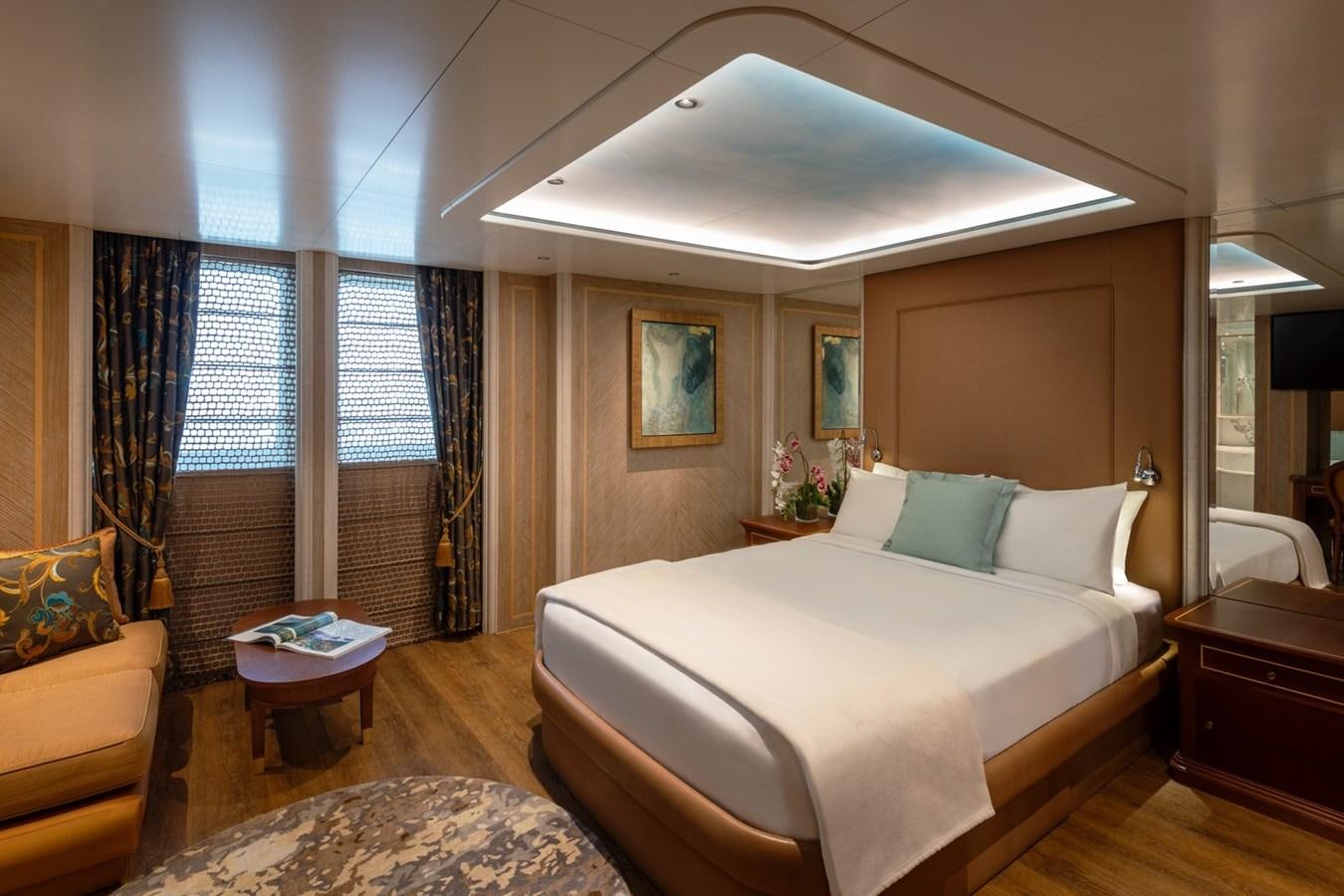 a bedroom with a bed and a chair aboard MOONLIGHT II Yacht for Sale