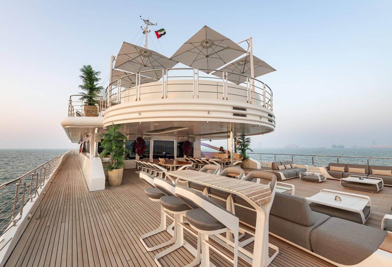 a deck with chairs and tables on it by the water aboard MOONLIGHT II Yacht for Sale