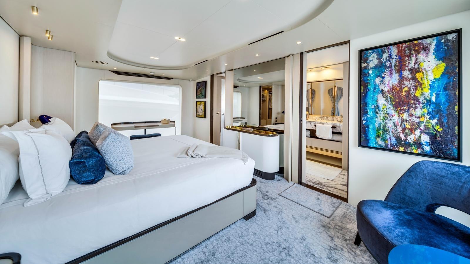 a room with a bed and a chair aboard ONE & ONLY Yacht for Sale