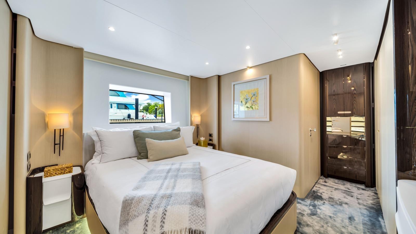 a bedroom with a bed and a wood door aboard ONE & ONLY Yacht for Sale