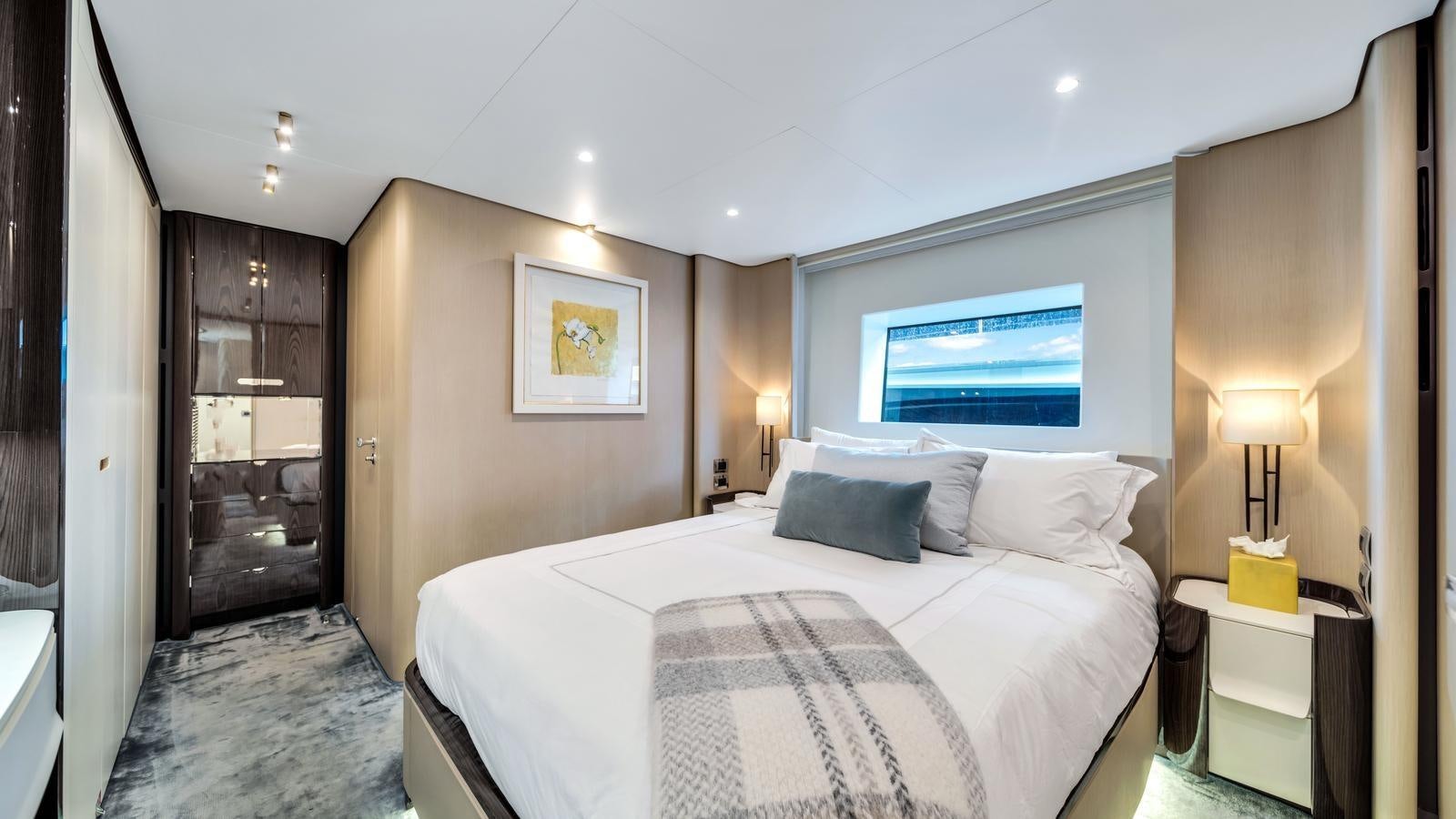 a bedroom with a bed and a television on the wall aboard ONE & ONLY Yacht for Sale