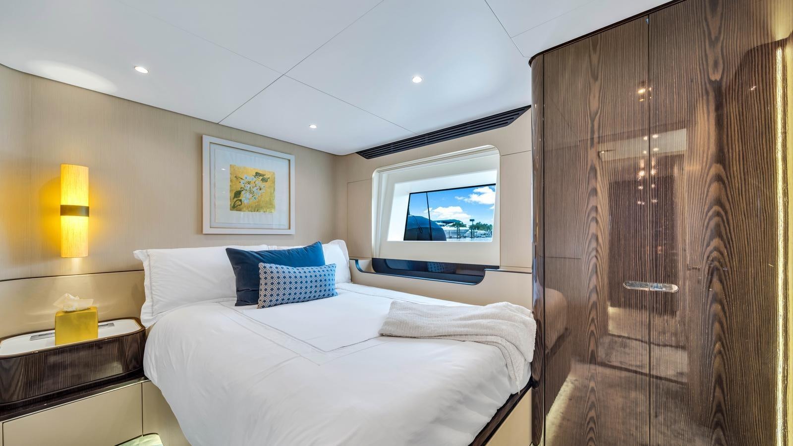 a room with a bed and a television aboard ONE & ONLY Yacht for Sale