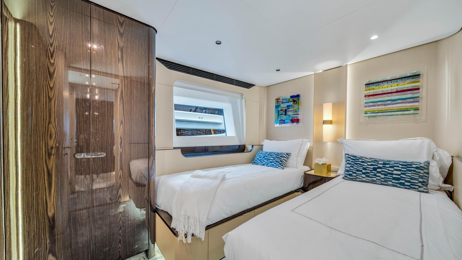 a room with a bed and a television aboard ONE & ONLY Yacht for Sale