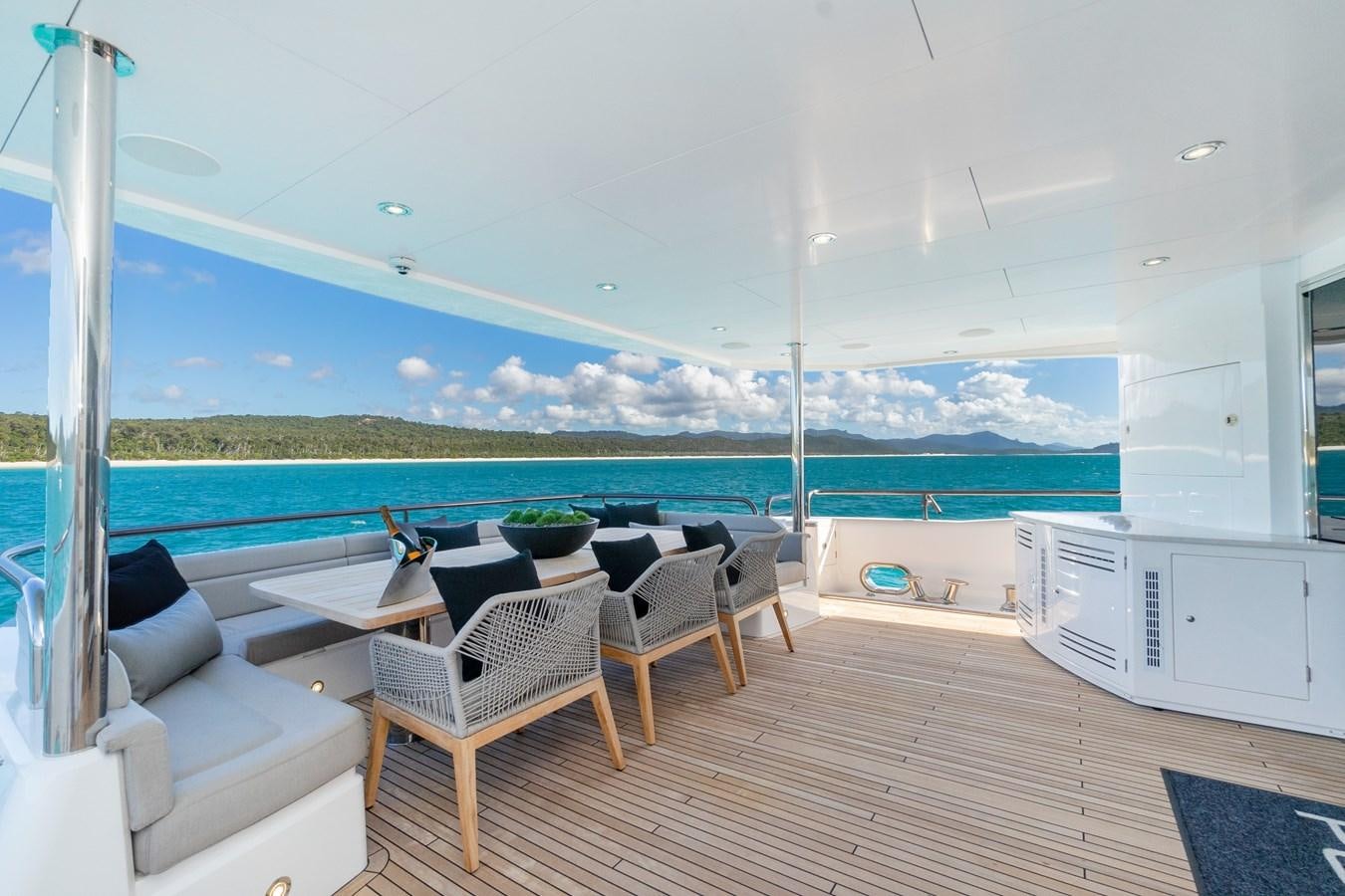 a deck with chairs and a table aboard POPS Yacht for Sale