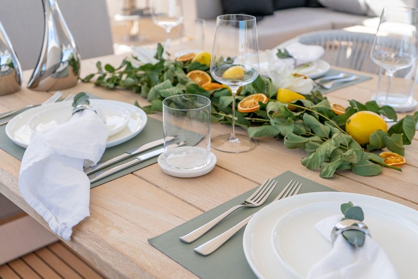 a table with plates and glasses aboard POPS Yacht for Sale
