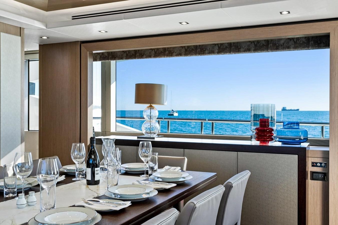 a table with plates and wine glasses aboard POPS Yacht for Sale