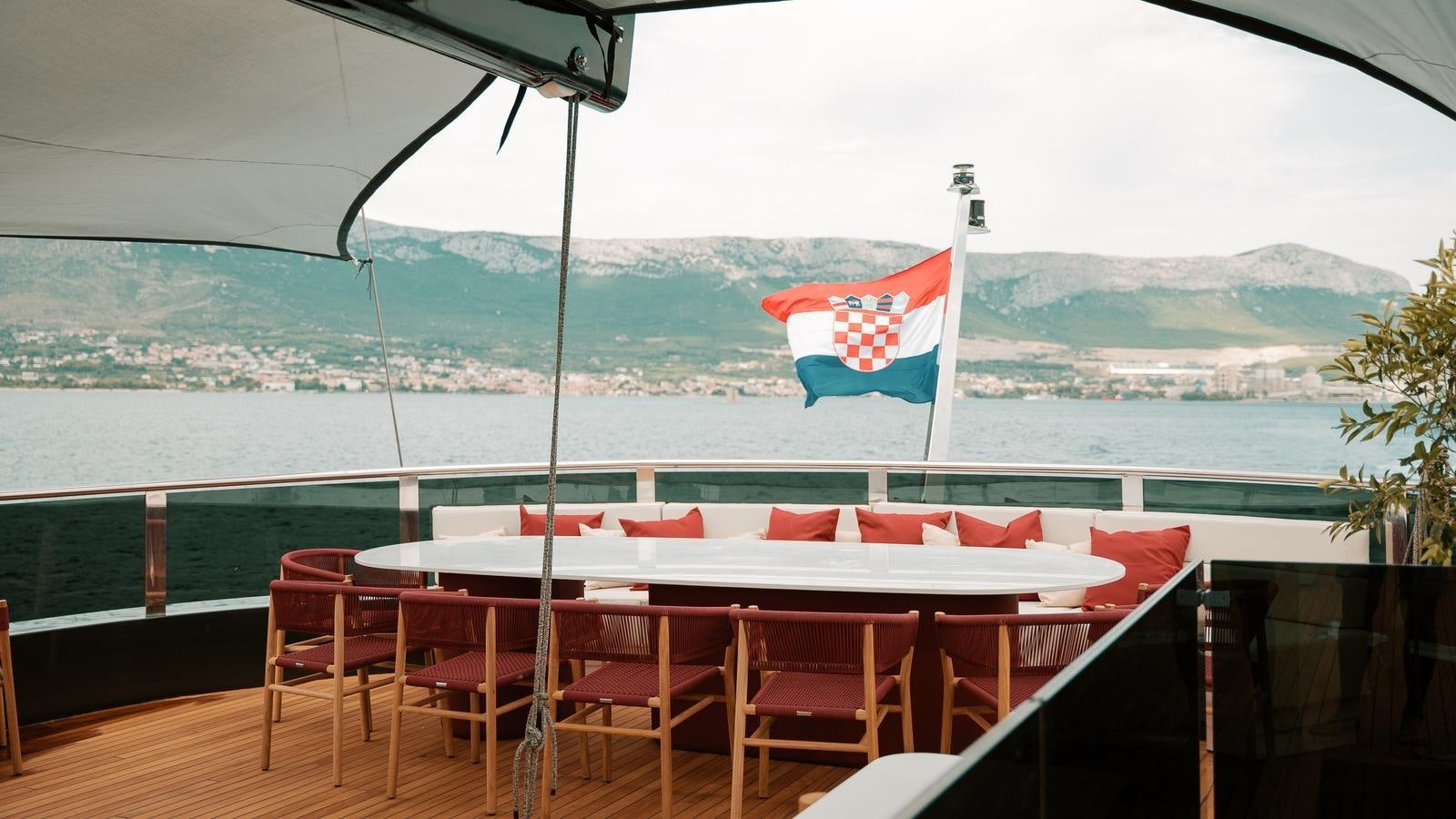 a table with red and white cloths and a flag on it aboard REPOSADO Yacht for Sale