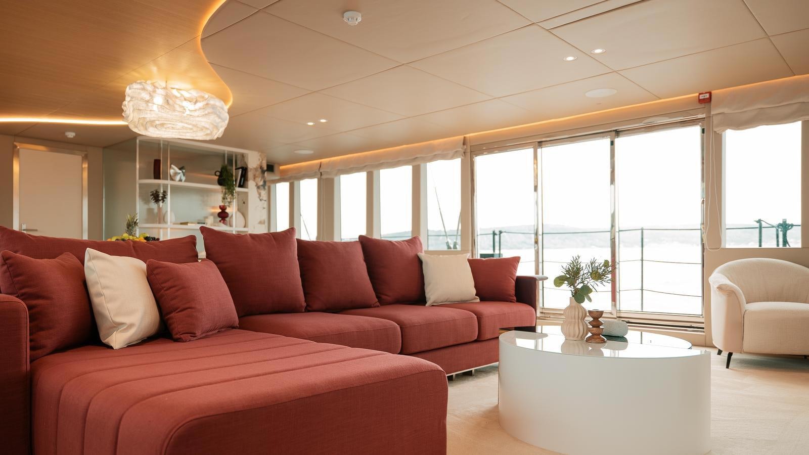 a living room with a red couch aboard REPOSADO Yacht for Sale