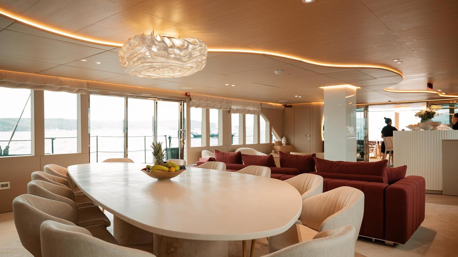 a large living room with a large table and chairs aboard REPOSADO Yacht for Sale