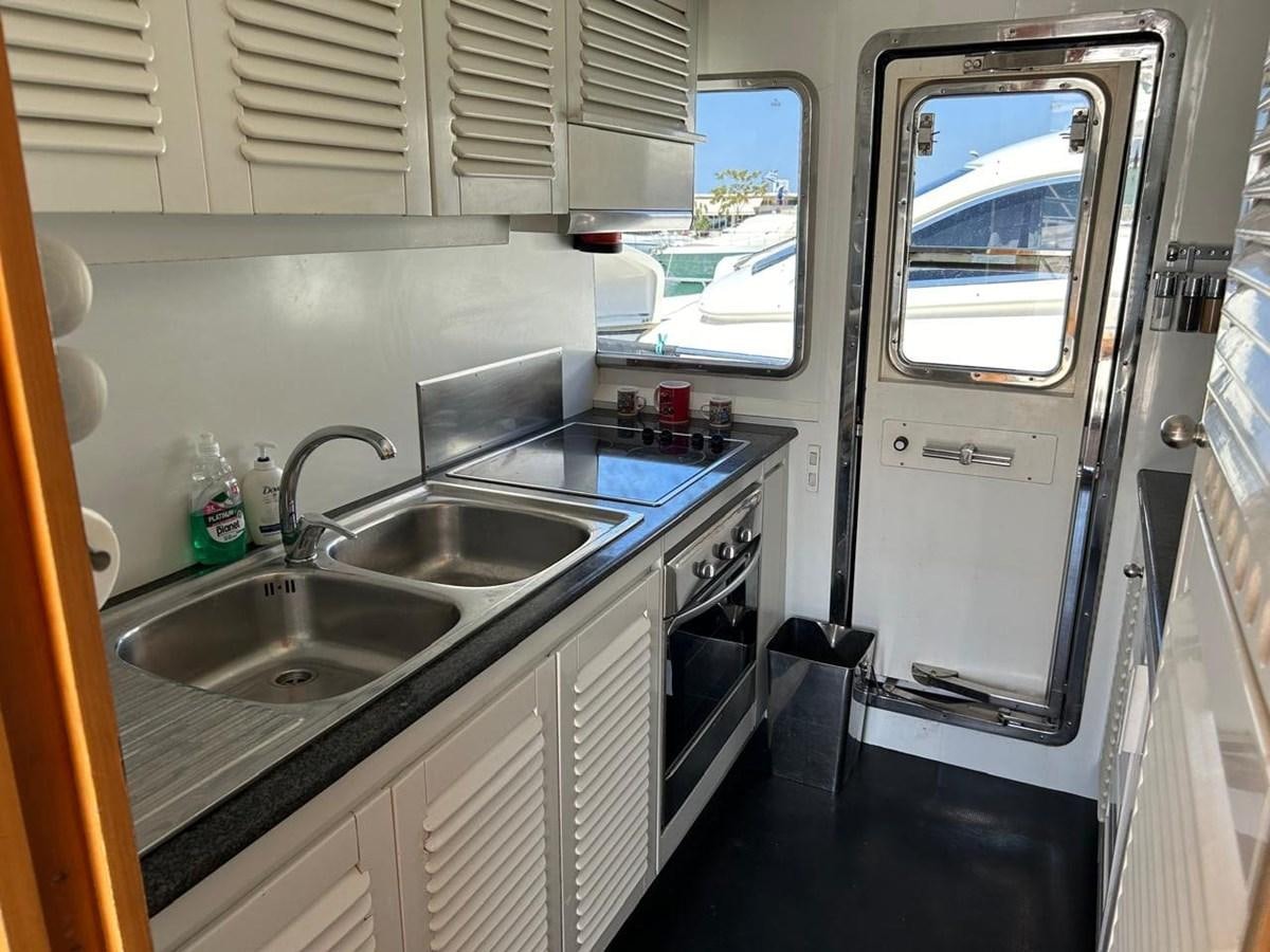 a kitchen with a sink and a refrigerator aboard MILMAR Yacht for Sale