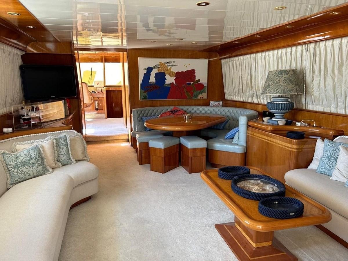 a living room with a table and couches aboard MILMAR Yacht for Sale