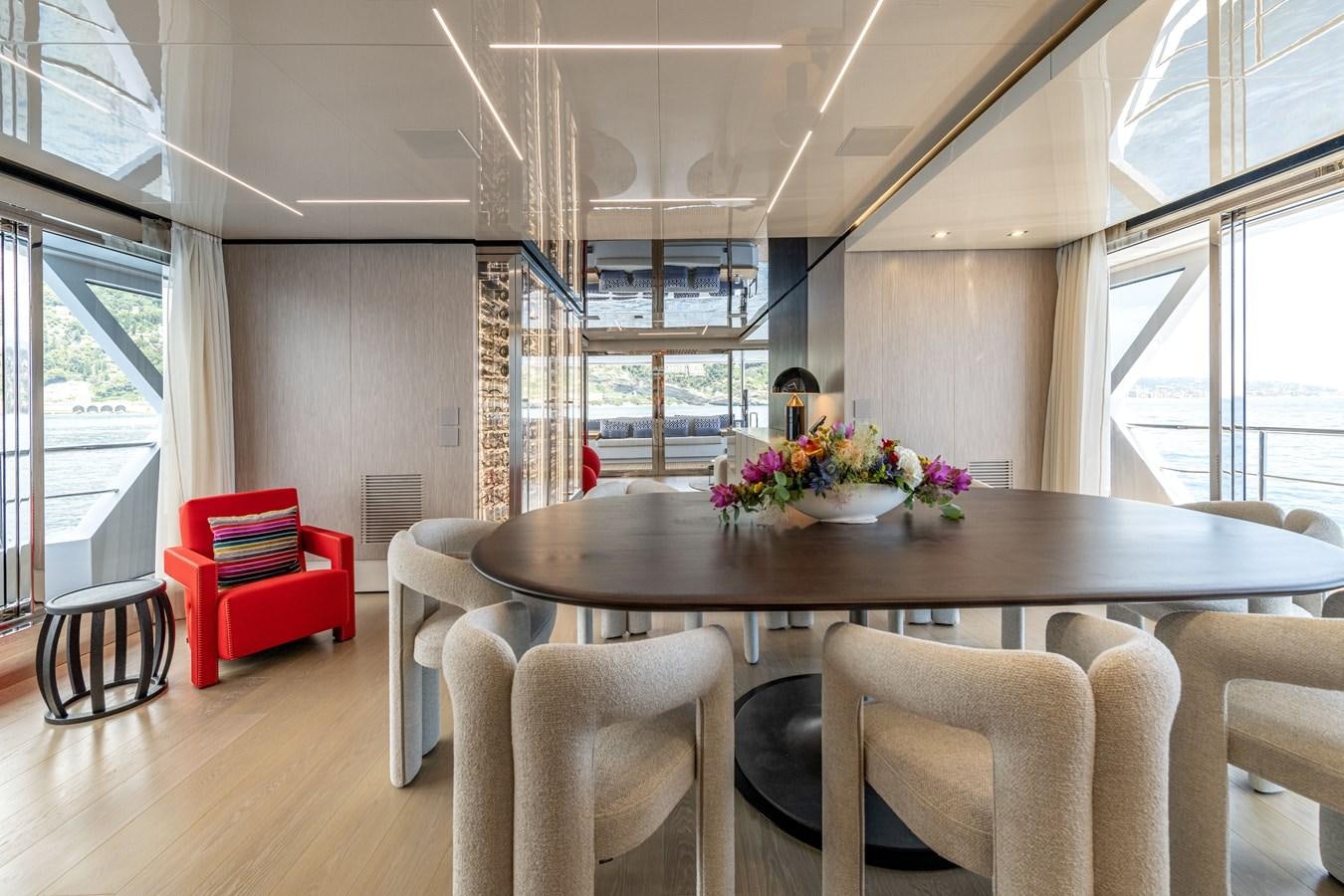 a dining table in a room aboard RSY C.129 Yacht for Sale