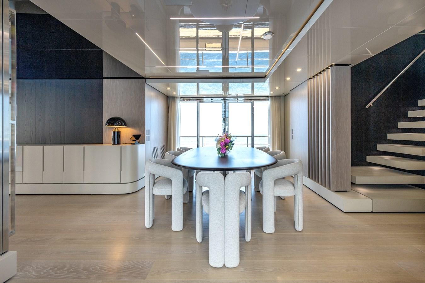 a room with a table and chairs aboard RSY C.129 Yacht for Sale