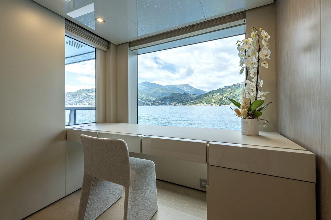 a room with a window and chairs aboard RSY C.129 Yacht for Sale