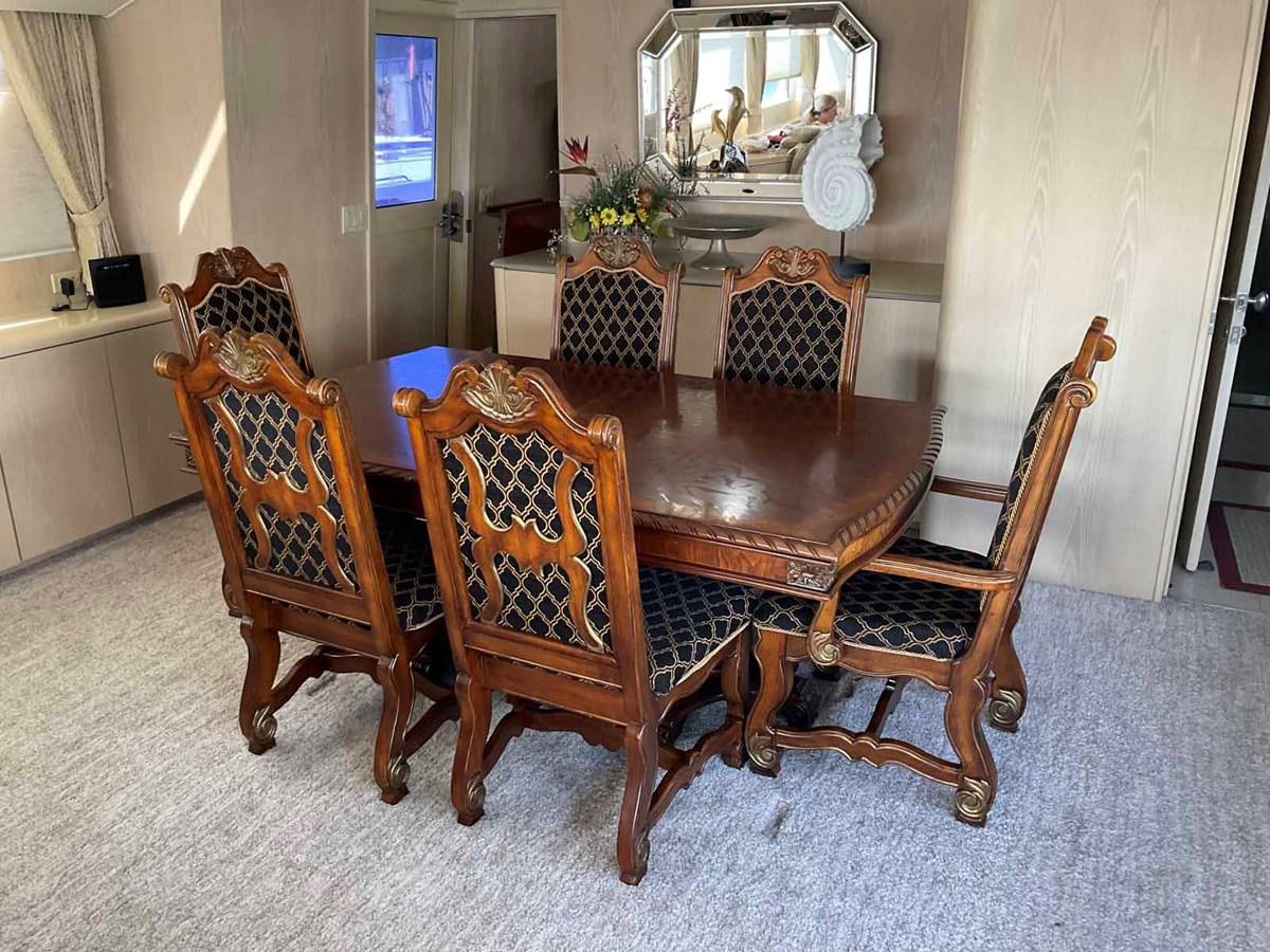 a dining room table and chairs aboard MON SHERI Yacht for Sale