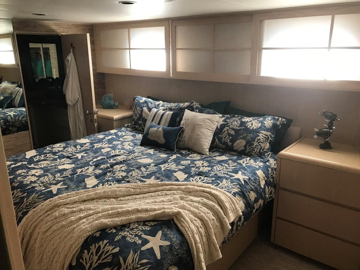 a bed with blue sheets aboard MON SHERI Yacht for Sale