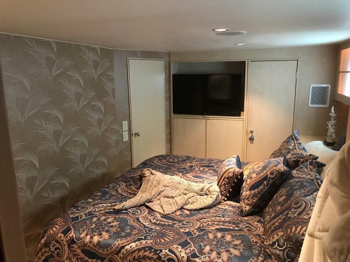 a bedroom with a bed and a television aboard MON SHERI Yacht for Sale