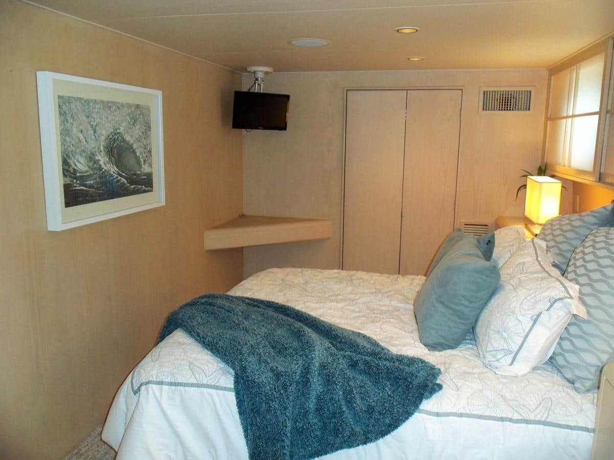 a bed with a blue blanket aboard MON SHERI Yacht for Sale