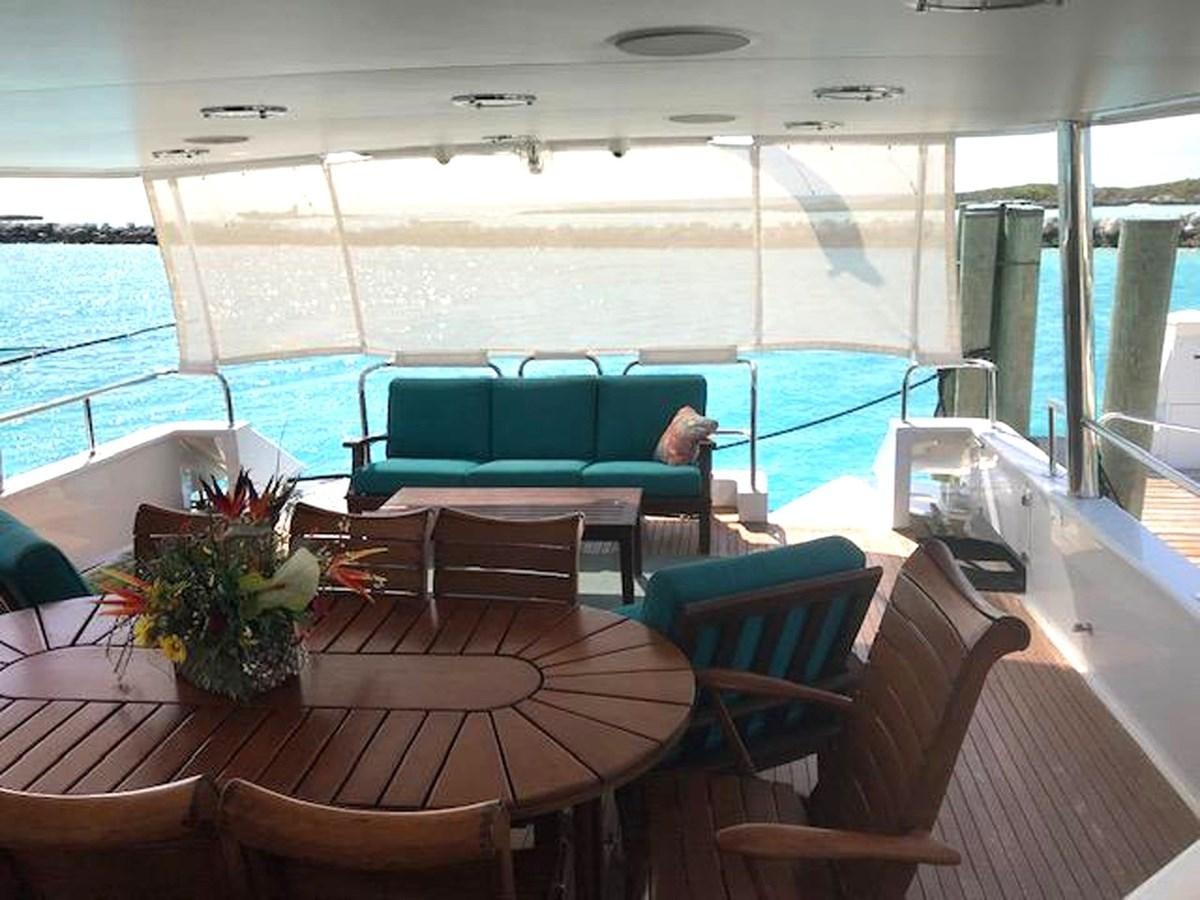a boat with a table and chairs aboard MON SHERI Yacht for Sale