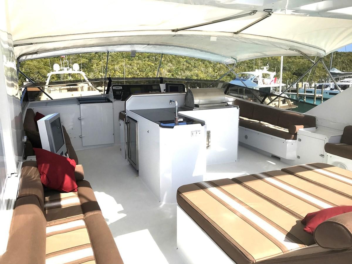 a boat with a deck and a deck with a tent and a picnic table and chairs aboard MON SHERI Yacht for Sale