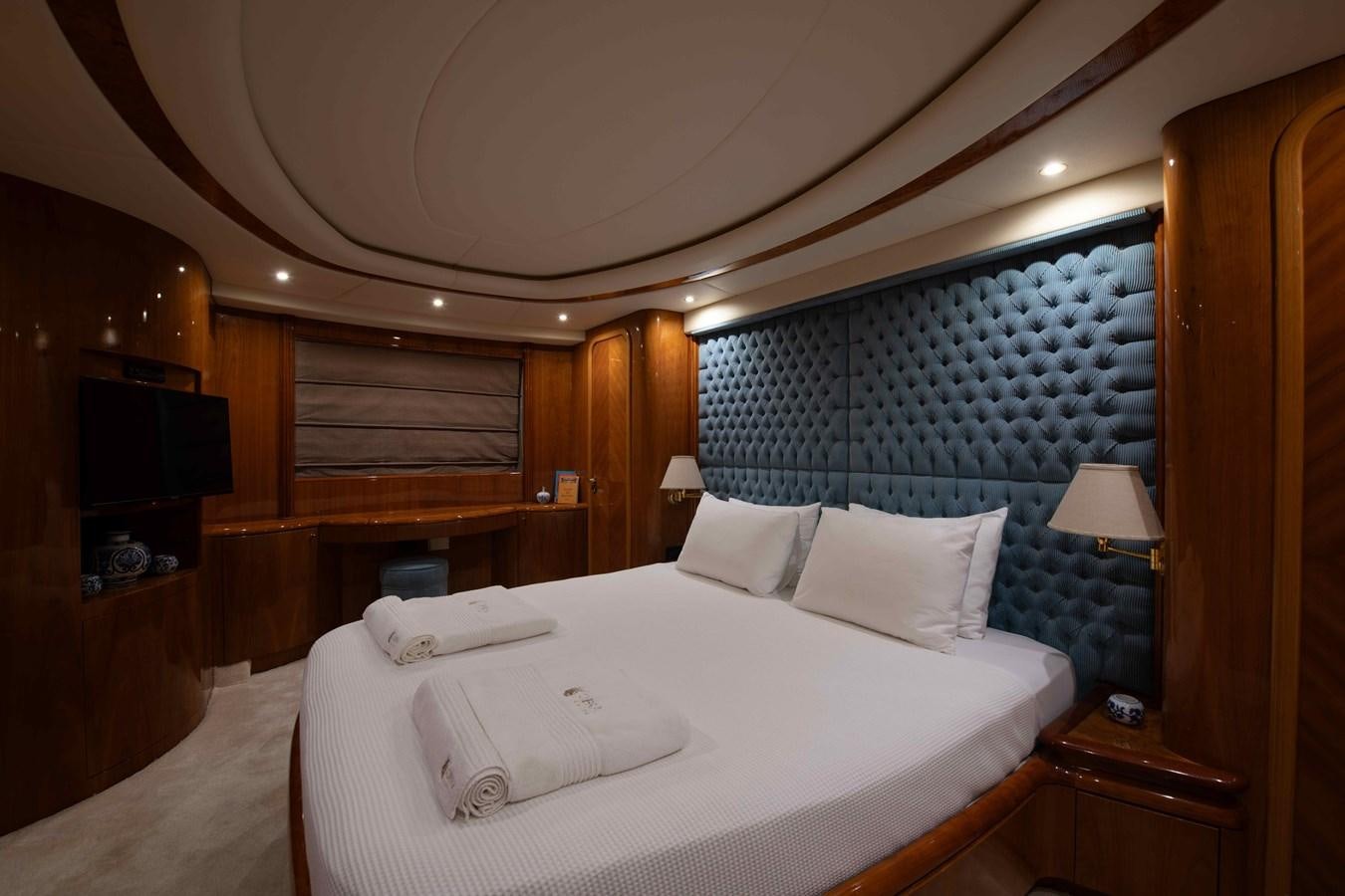 a room with a bed and a television aboard STOLI Yacht for Sale