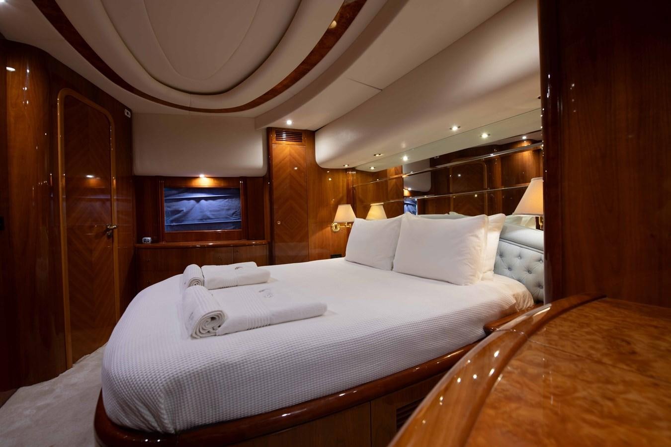 a room with a bed and a mirror aboard STOLI Yacht for Sale