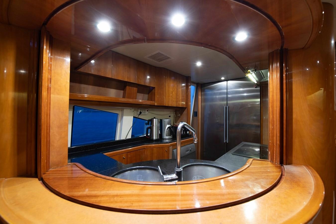 a kitchen with a sink and a large mirror aboard STOLI Yacht for Sale