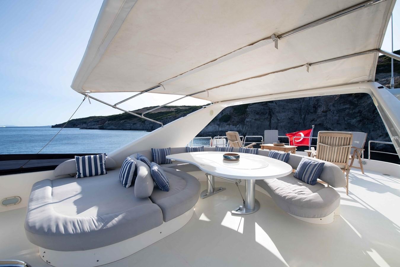 a lounge area with a table and chairs on it aboard STOLI Yacht for Sale