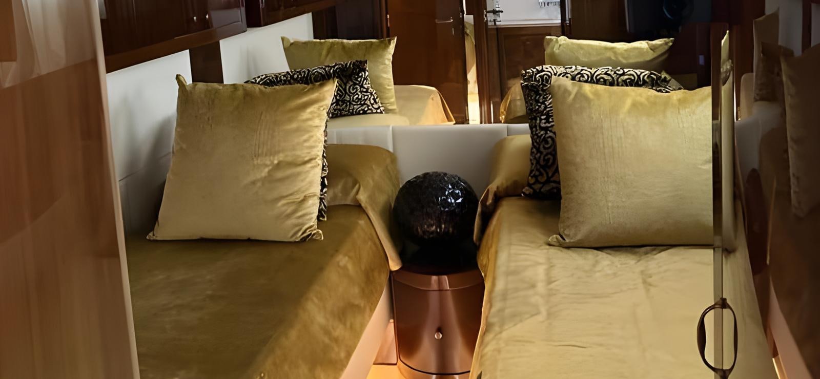a bed with a black headboard and a black mask on top aboard UNICA Yacht for Sale