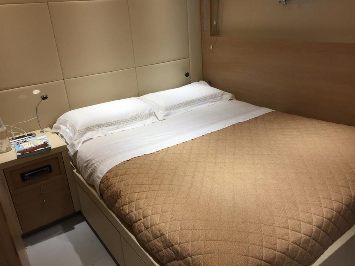 a bed with a wooden headboard aboard PATHOS Yacht for Sale