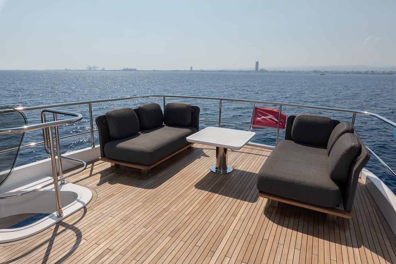 a deck with chairs and a table on it aboard GREY T Yacht for Sale