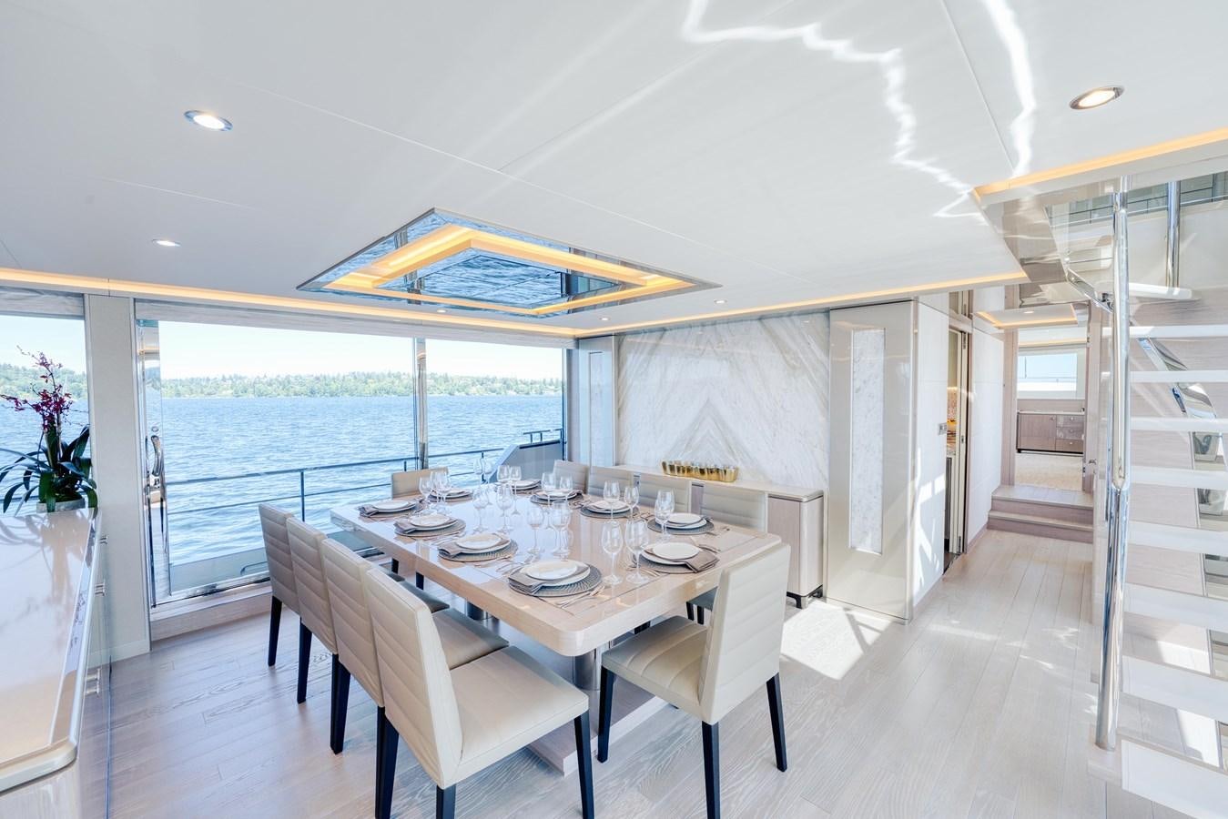 a dining table and chairs on a deck next to a large body of water aboard OCEAN ALEXANDER 32L11 Yacht for Sale
