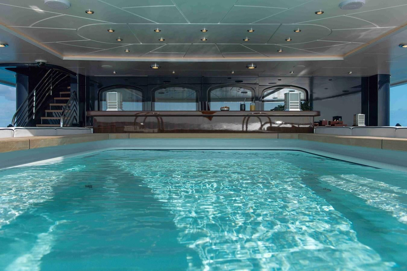 a swimming pool with a glass wall aboard AURORA Yacht for Sale